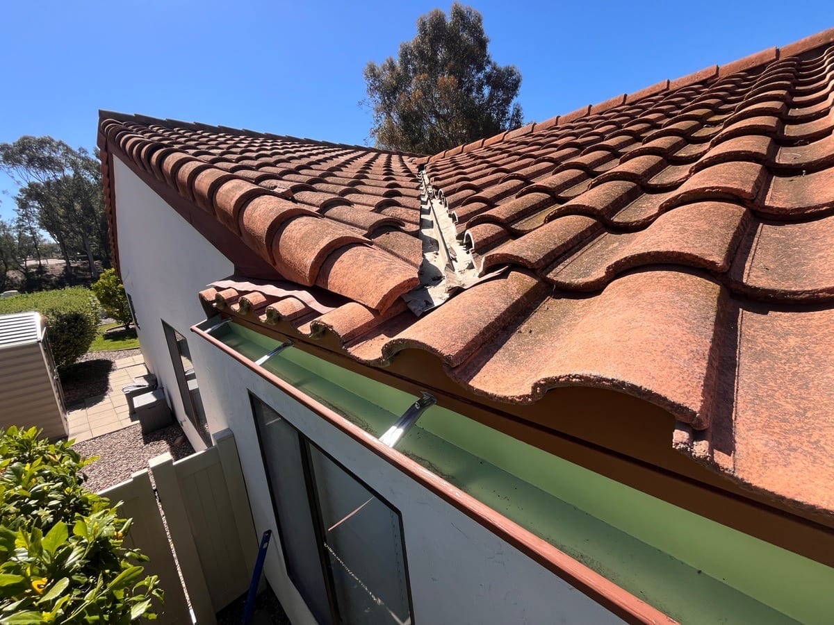 Tile roof valley and gutter along a stucco home.
